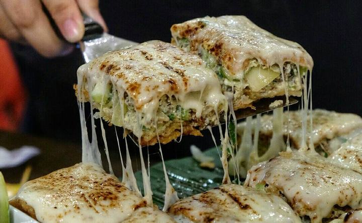 Martabak Mozzarella Leleh: Potongan martabak mozzarella yang menggoda, dengan keju leleh yang melimpah di setiap gigitan